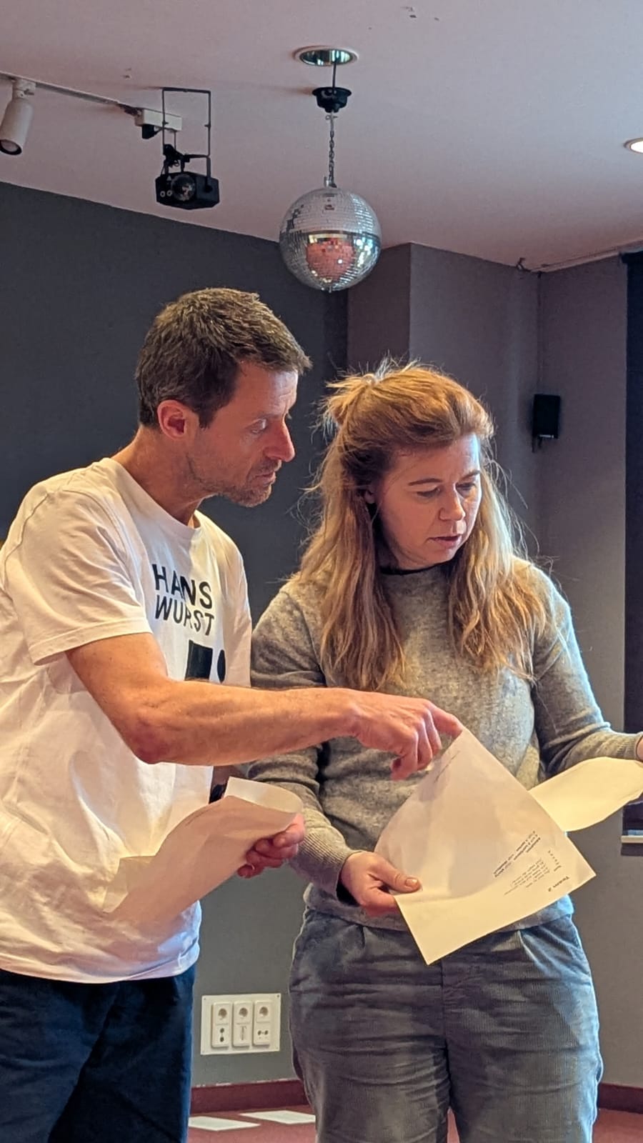 eine Frau und ein Mann schauen gemeinsam in einen Text, beide konzentriert.